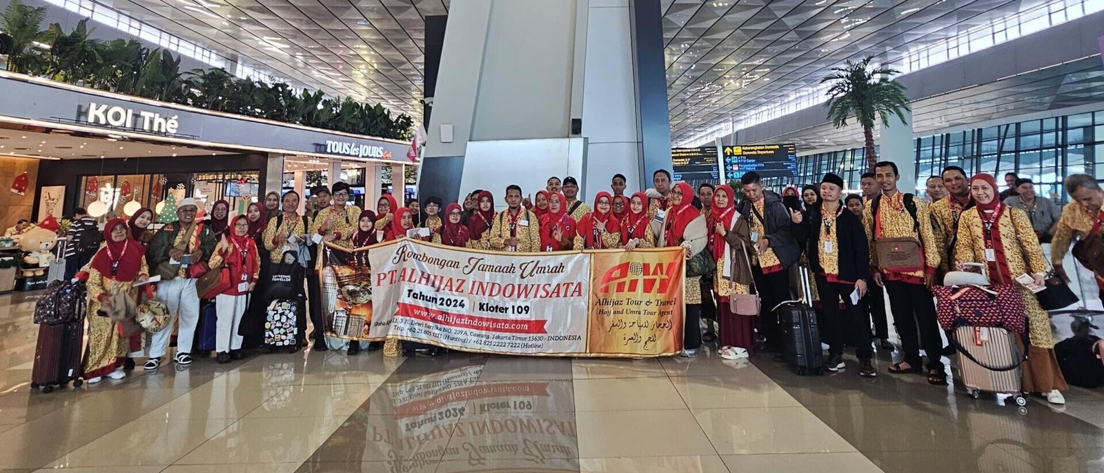 Jamaah Paket Umroh 2025 Alhijaz berfoto bersama di Bandara dengan spanduk